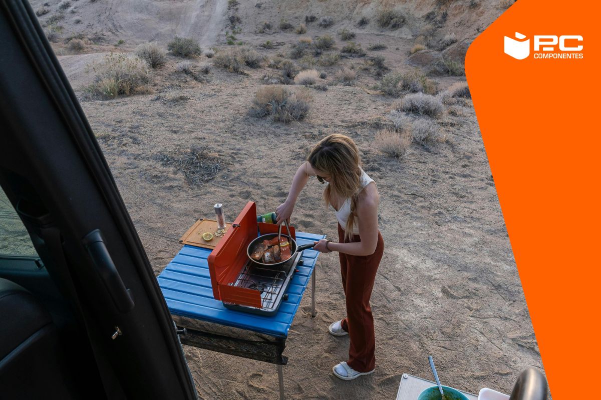 Una mujer utilizando una de las mejores cocinas portátiles para camping Una mujer utilizando una de las mejores cocinas portátiles para camping