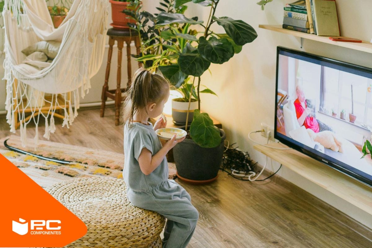 Una bambina piccola che guarda una delle migliori piccole televisioni in una cucina. Una bambina piccola che guarda una delle migliori piccole televisioni in una cucina