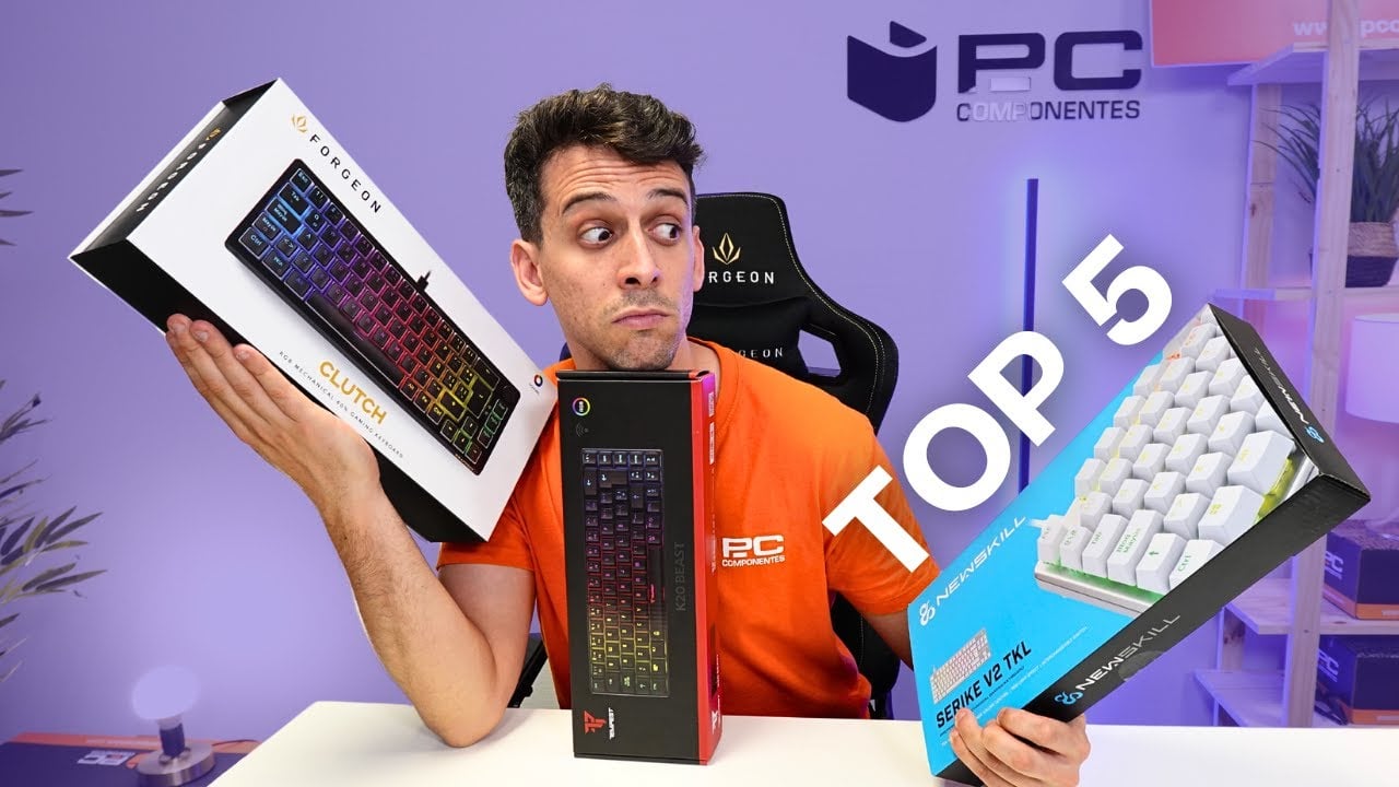 El experto en periféricos de PcComponentes, sostiene dos teclados gaming en sus manos