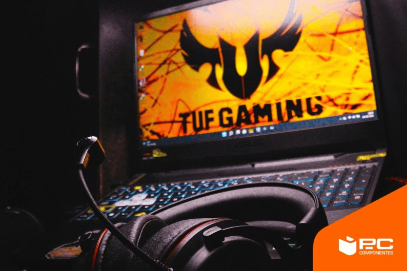 um portátil gaming ASUS TUF de fundo com uns auriculares gaming em primeiro plano