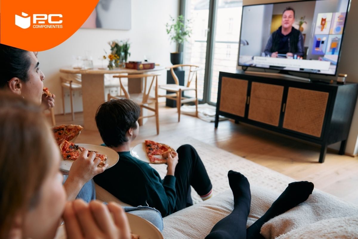 Una familia viendo un programa en uno de los televisores más finos Una familia viendo un programa en uno de los televisores más finos