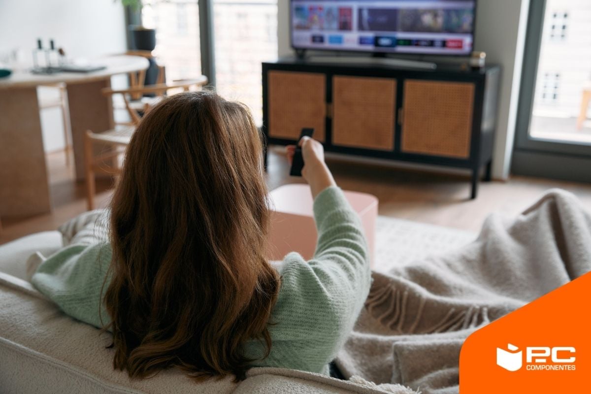 Una persona viendo cuánta energía consume el televisor Una persona viendo cuánta energía consume el televisor