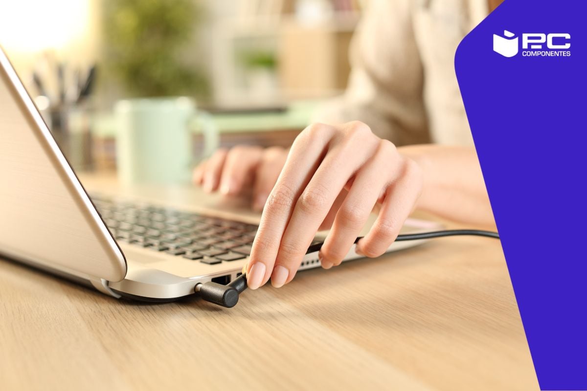 Una persona conecta el cargador a su pc portátil
