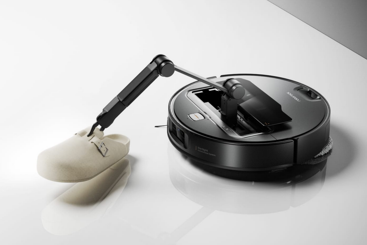Robot aspirador con brazo recogiendo zapatilla