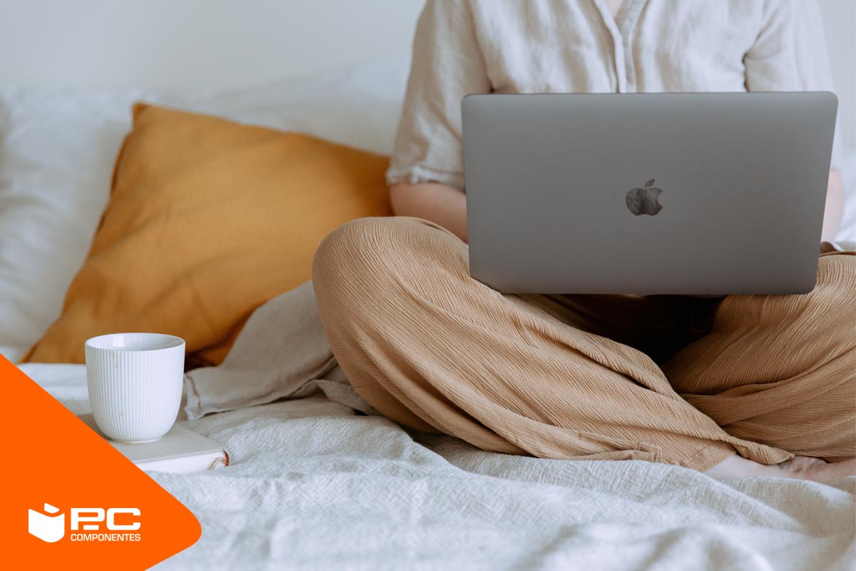 Qué es Threads Chica sentada en la cama con un ordenador portátil y un café