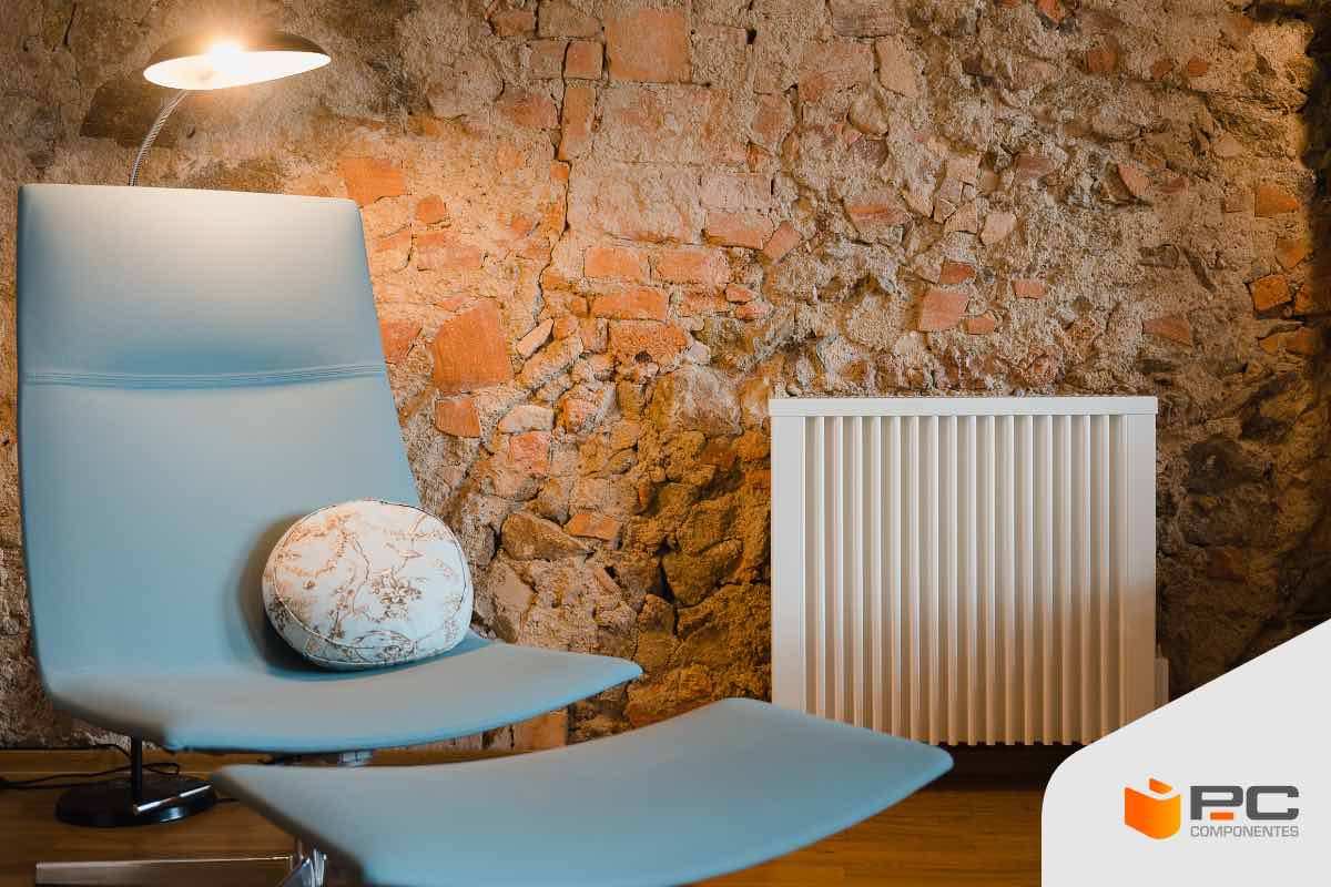 ¿Radiador, convector o emisor térmico? Un radiador en un salón junto a un sofá