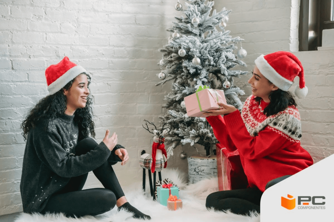 Duas mulheres vestidas de natal com um dos melhores presentes para mulher na mão Duas mulheres vestidas de natal com um dos melhores presentes para mulher na mão